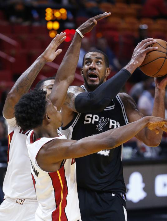 Pemain San Antonio Spurs, LaMarcus Aldridge (kanan) mencoba melewati adangan pemain Miami Heat pada laga NBA basketball game di Miami, (25/10/2017). Spurs kalahkan Heat 117-100.  (AP/Wilfredo Lee)