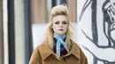 Aktris Elle Fanning memperagakan busana karya Miu Miu pada Paris Fashion Week Fall-Winter 2018, Selasa (6/3). Rambutnya ditata dengan style sasak tinggi seperti mode rambut tahun 60an dan polesan make up smooky eyes yang bold (Vianney Le Caer/Invision/AP)