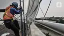 Aktivitas pekerja saat menyelesaikan pembangunan instalasi Flyover Cakung, Jakarta Timur, Selasa (16/3/2021). Progres pembangunan flyover yang menghubungkan kawasan Duren Sawit dengan Cakung tersebut saat ini telah mencapai 96,44 persen. (merdeka.com/Iqbal S. Nugroho)
