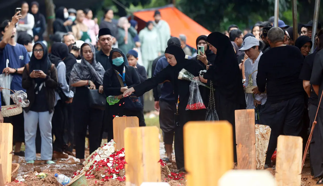Beberapa kerabat dekat menabur bunga di sisi makam Oxavia Aldiano atau lebih dikenal dengan nama Vidi Aldiano di Tempat Pemakaman Umum (TPU) Tanah Kusir, Jakarta, Minggu (8/3/2026). (Kapanlagi.com/Budy Santoso)