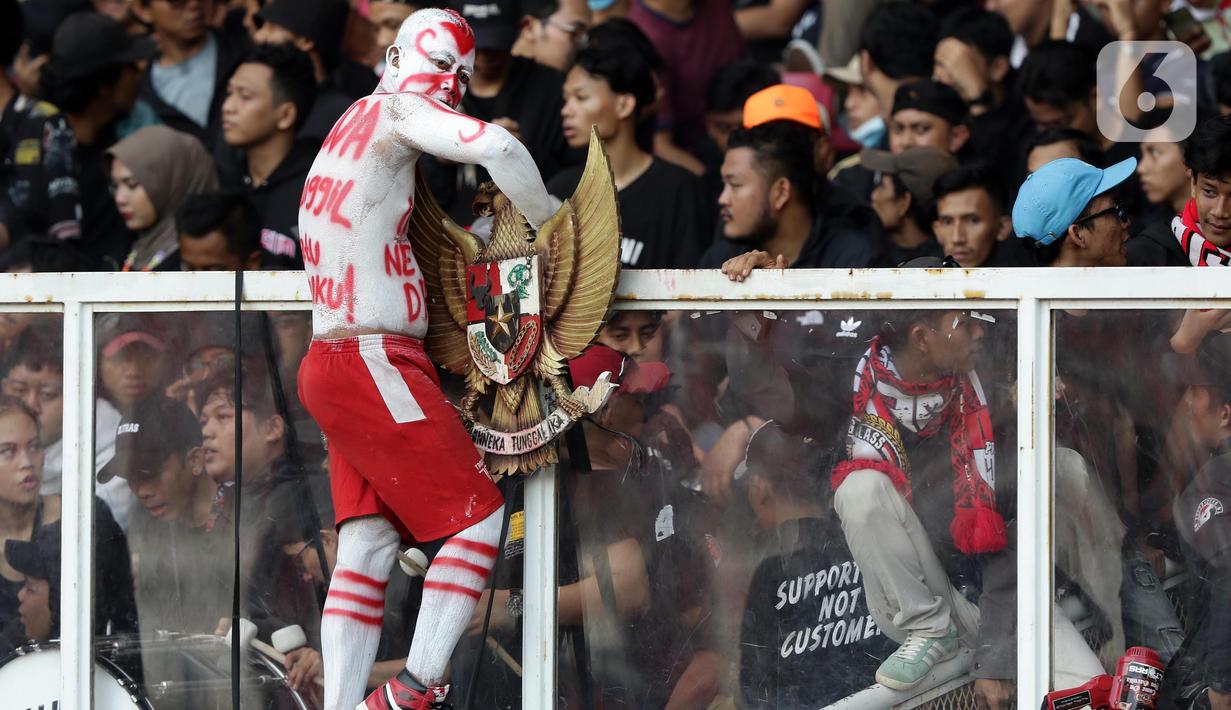 Suporter tim garuda memasang lambang negara Indonesia saat menyaksikan laga timnas Indonesia melawan Vietnam pada semifinal leg pertama Piala AFF 2022 di Stadion Utama Gelora Bung Karno, Jakarta, Jumat (6/1/2023). Indonesia akan melakoni laga tandang semifinal Piala AFF 2022 melawan Vietnam pada Senin (9/1). (Liputan6.com/Helmi Fithriansyah)