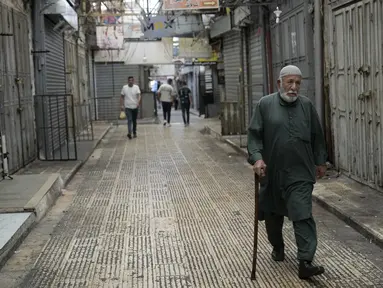 Seorang pria Palestina berjalan melalui kota Nablus di Tepi Barat, di mana toko-toko tutup sebagai bagian dari pemogokan umum menyusul pembunuhan pemimpin Hamas Ismail Haniyeh, Rabu (31/7/2024). (AP Photo/Majdi Mohammed)