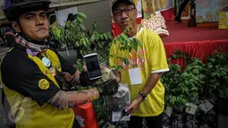 Warga mendapatkan bibit pohon belimbing disela kegiatan Coolant Star Fruit di arena Car Free Day, Jakarta, Minggu (25/9). Pembagian bibit itu untuk mengajak masyarakat melestarikan lingkungan dengan menanam tanaman produktif.  (Liputan6.com/Faizal Fanani)