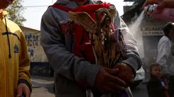 Warga Meksiko membawa patung Santa Muerte berkeliling saat merayakan tahun baru di Meksiko, Minggu (1/1/2017). Santa Muerte dikenal sebagai mahluk pencabut nyawa berwajah tengkorak dengan membawa tongkat bercelurit tajam. (REUTERS/Carlos Jasso)