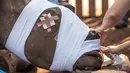 Seekor badak dipakaikan perban oleh dokter hewan di Bela Bela, Johannesburg, Afrika Selatan (20/5). Badak tersebut korban para pemburu liar yang mengincar cula badak. (AFP Photo/Mujahid Safodien)