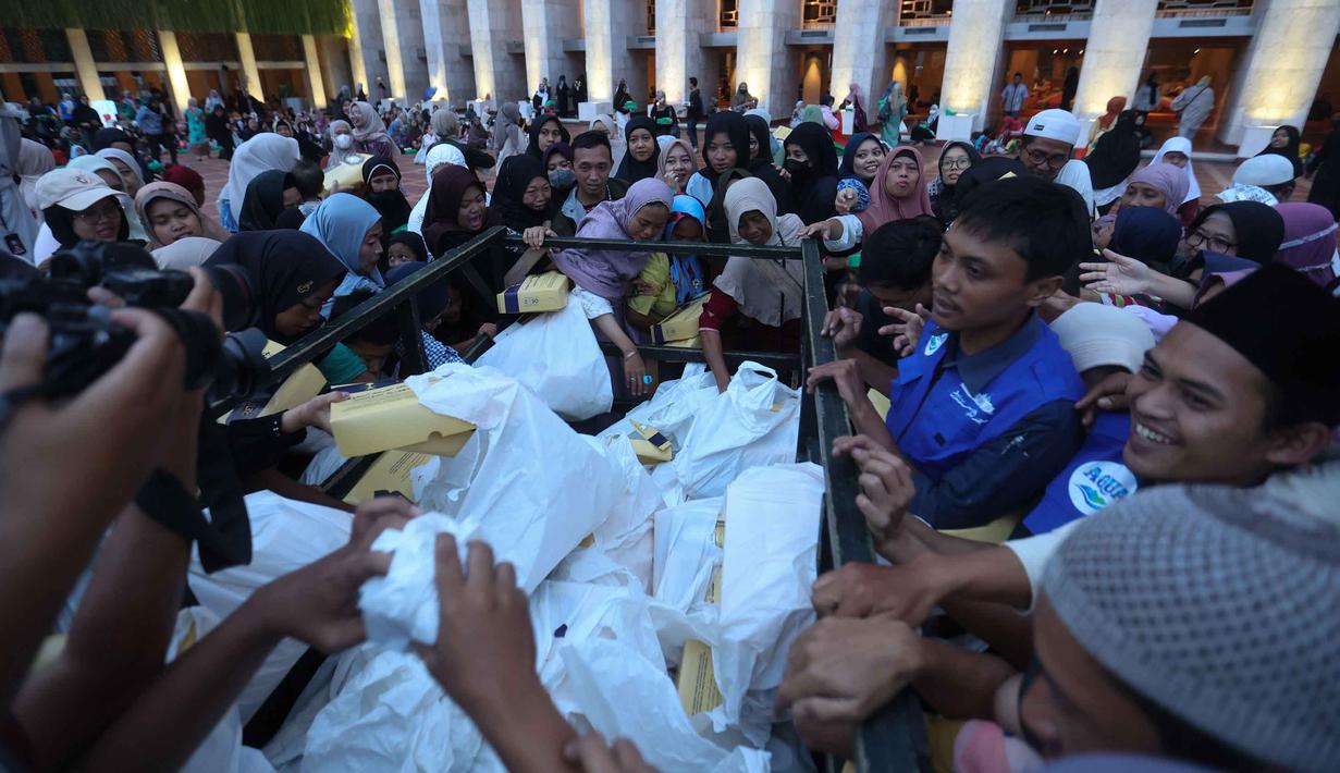 Sepanjang Ramadan, makanan berbuka puasa gratis ini tidak hanya diperuntukkan bagi umat Muslim, namun juga bagi masyarakat umum dan wisatawan yang sedang berada di sekitar kawasan tersebut. Tampak dalam foto, warga berebut makanan untuk berbuka puasa pada hari pertama Ramadan 1447 Hijriah di Masjid Istiqlal, Jakarta, Selasa (19/2/2026). (Kapanlagi.com/Budy Santoso)