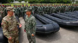 Kolonel Ernest Lee berbincang dengan Mayjen Marinir Filipina Emmanuel Salamat saat serah terima senjata baru yang diberikan AS ke Filipina di kota Taguig, sebelah timur Manila, Filipina (5/6). (AP Photo / Bullit Marquez)
