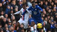 Pemain Chelsea, Benoit Badiashile (kanan) berebut bola dengan pemain Crystal Palace, Wilfried Zaha pada laga lanjutan Liga Inggris 2022/2023 di Stamford Bridge, London, 15 January 2023. Pemain berkebangsaan Prancis itu diboyong dari AS Monaco dengan harga 38 juta euro pada bursa transfer Januari 2023. (AFP/Ben Stansall)