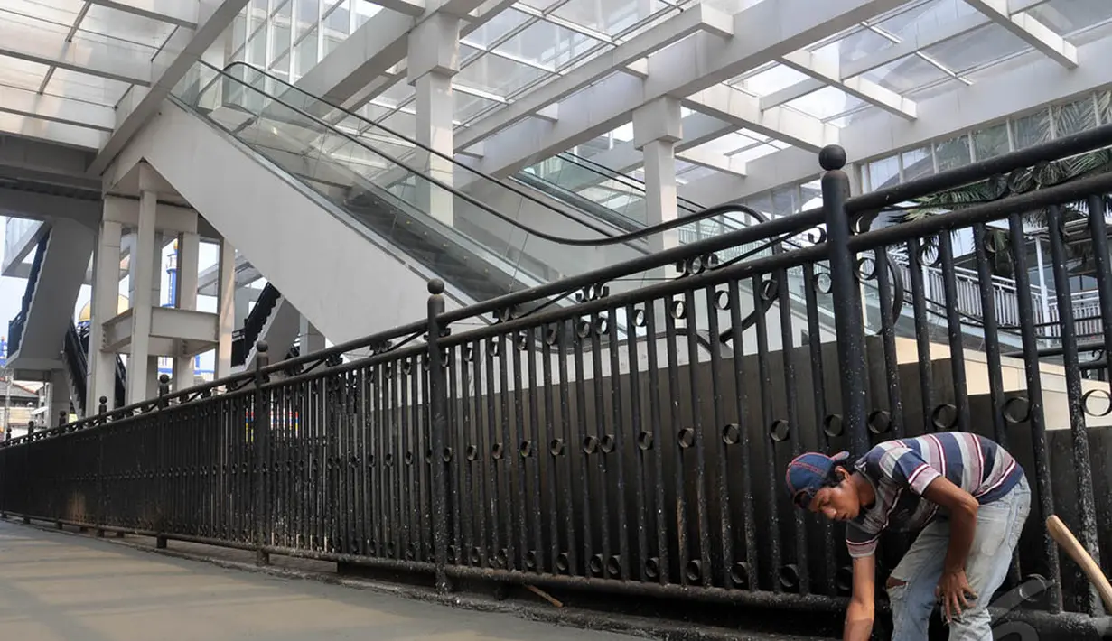 Para pekerja sedang menyelesaikan perbaikan jalan di Terminal Manggarai, Jakarta, Minggu (28/8/2014) (Liputan6.com/Miftahul Hayat)