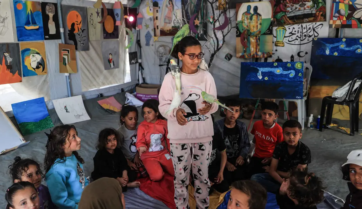 Sekitar 61 persen menderita gangguan stres pasca-trauma (PTSD), 38 persen menderita depresi, dan 41 persen menderita kecemasan. Tampak dalam foto, anak-anak pengungsi Palestina mengikuti sesi konseling psikologis di sebuah studio seni yang menggunakan hewan peliharaan dan burung di daerah Al-Zawaida, Jalur Gaza Tengah, pada Selasa 21 April 2026. (Eyad Baba/AFP)