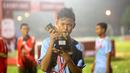 Pemain Terbaik Rusun Cup 2015 dari Rusun Daan Mogot, Mohammad Sobri, berpose dengan pialanya seusai laga final di Stadion Soemantri Brojonegoro, Jakarta, Minggu (8/11/2015). ( Bola.com/Nicklas Hanoatubun)