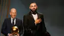 Pemain Real Madrid, Karim Benzema mengembangkan senyum saat terpilih memenangkan trofi Ballon d'Or 2022 di Theater du Chatelet, Paris, Prancis, Senin (17/10/2022). Musim 2021-2022, Karim Benzema berhasil mencetak 50 gol dan 16 assists dari 56 pertandingan di level klub dan timnas. (AP Photo/Francois Mori)