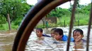 Hujan yang turun sejak Minggu (8/2) lalu, mengakibatkan kawasan perumahan mewah Garaharaya di Tangerang, Banten terendam air setinggi lebih kurang 90 cm. Tampak sejumlah bocah asyik bermain air, Selasa (10/2/2015). (Liputan6.com/Faisal R Syam)