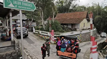 Penduduk desa menggunakan mobil bak terbuka dievakuasi dari rumah mereka di lereng Gunung Merapi, di Krinjing, Jawa Tengah, Jumat (6/11/2020). Evakuasi dilakukan bagi warga lereng Merapi menyusul peningkatan status aktivitas vulkanik gunung tersebut. (AP Photo/Taufiq Rozzaq)