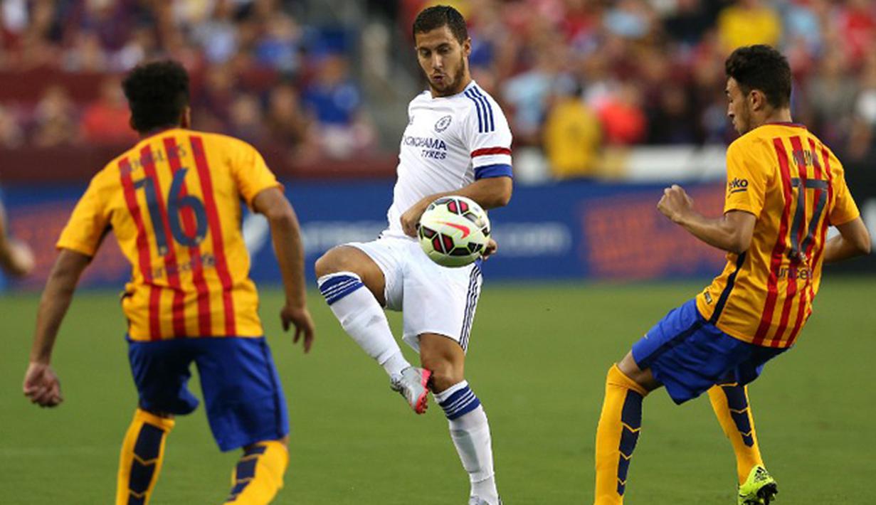 Gelandang Chelsea, Eden Hazard mengumpan bola dari kejaran dua pemain Barcelona saat International Champions Cup 2015 di Landover, Maryland, Rabu (29/7/2015). Chelsea menang 4-2 lewat adu penalti, usai bermain imbang 2-2 waktu normal. (AFP/Patrick Smith)