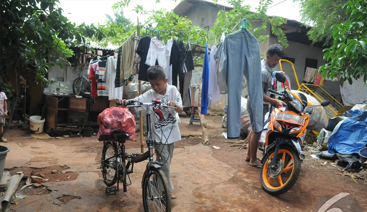Sony Wakwaw bersiap membawa beberapa barang dengan sepeda saat pindah kerumah barunya di kawasan Cibubur, Jakarta Timur. Foto diambil pada Kamis (4/12/2014). (Liputan6.com/Herman Zakharia)