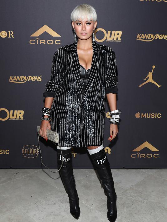 Penampilan Agnez Mo di karpet merah pesta ulang tahun ke-42 DJ Khaled di Los Angeles, 2 Desember 2017. Agnez menyempurnakan gayanya dengan boots tinggi Christian Dior, clutch bling-bling dan gelang ukuran besar. (Jerritt Clark/Getty Images for Ciroc/AFP)