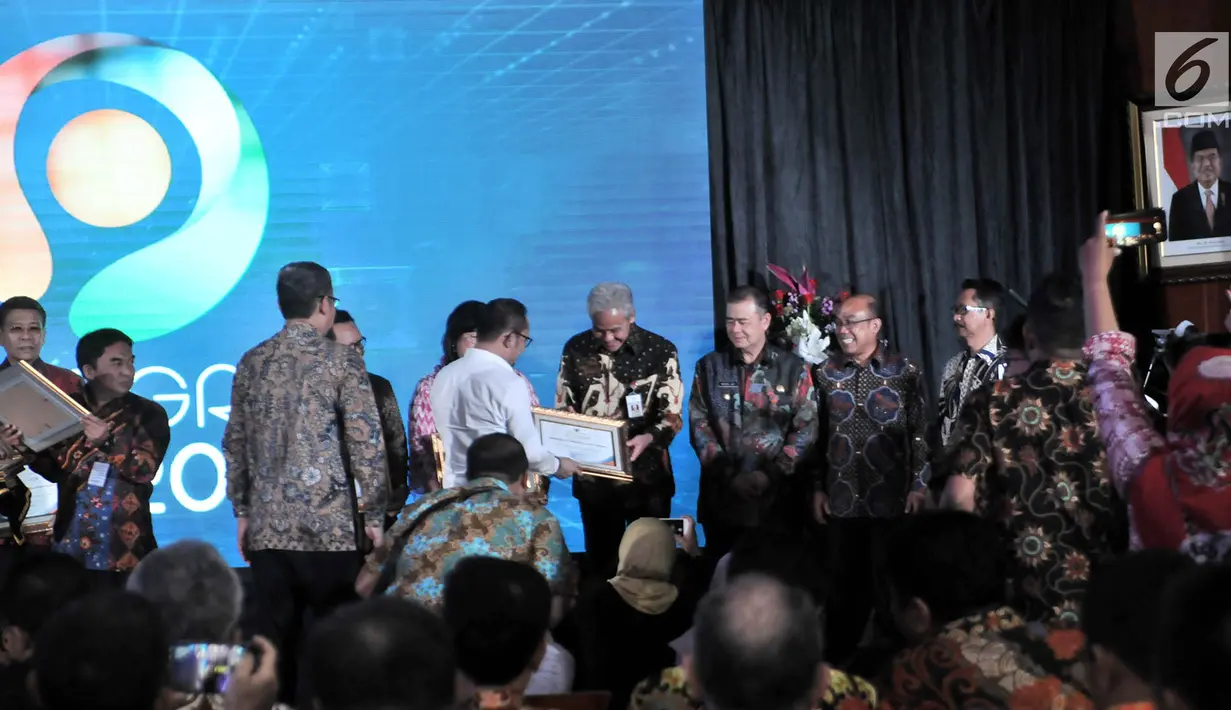 Gubernur Jawa Tengah Ganjar Pranowo (tengah) menerima penghargaan dari Menteri Ketenagakerjaan Hanif Dhakiri dalam Indeks Pembangunan Ketenagakerjaan (INTEGRA) 2018 di Kantor Kemnaker, Jakarta, Senin (19/11). (Merdeka.com/Iqbal Nugroho)