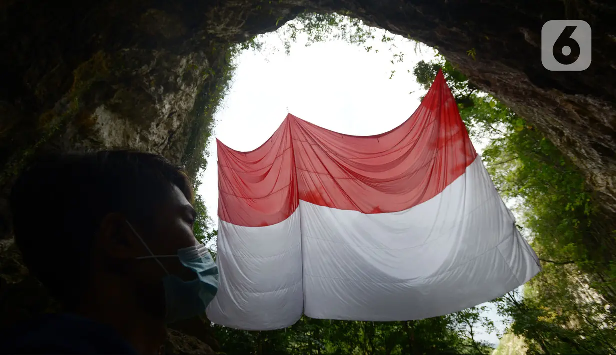 Pegiat panjat tebing membentangkan Bendera Merah Putih memperingati HUT ke-75 RI di Tebing Kutalingkung, Jawa Barat, Senin (17/8/2020). Pengibaran bendera untuk menyelamatkan tebing Kutalingkung yang memiliki potensi destinasi wisata  dari aktivitas pertambangan. (merdeka.com/Imam Buhori)