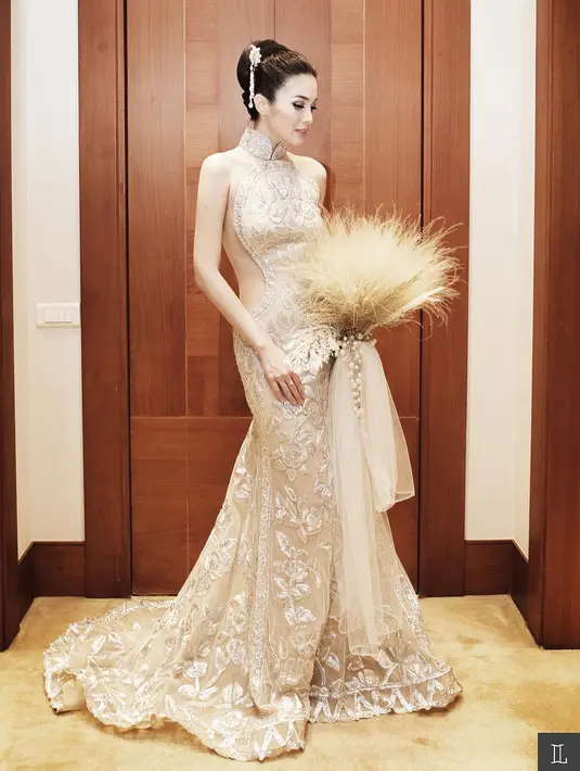Sandra Dewi tampil anggun dalam balutan cheongsam model mermaid nuansa emas yang cantik saat tea pai. [Instagram].