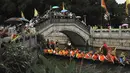 Peserta perahu naga dari desa Panting mendayung di sepanjang kanal di kawasan bersejarah Teluk Lychee di Guangzhou di Provinsi Guangdong, China selatan, Jumat, 3 Juni 2022. Perlombaan perahu naga kembali digelar di beberapa bagian China untuk pertama kalinya sejak merebaknya pandemi pada akhir 2019, saat pembatasan dicabut bersama dengan penurunan besar  kasus COVID-19. (AP Photo/Caroline Chen)
