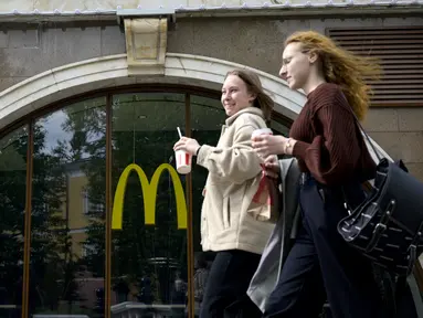 Perempuan berjalan melewati restoran McDonald's yang tutup di Moskow, Rusia pada 16 Mei 2022. Raksasa makanan cepat saji asal Amerika, McDonald's, akan keluar dari pasar Rusia dan menjual bisnisnya di negara yang semakin terisolasi itu, kata perusahaan tersebut pada Senin kemarin. (Natalia KOLESNIKOVA / AFP)