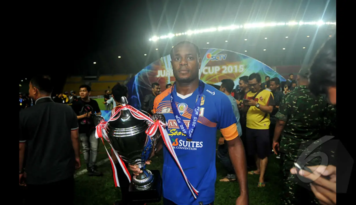 Pemain Belakang Arema Cronus, Victor Igbonefo berjalan sambil memegang piala usai mengalahkan Sriwijaya FC di final SCM Cup 2015 di Stadion Jakabaring,Selasa (27/1/2015). Arema Cronus unggul 1-0 atas Sriwijaya FC. (Liputan6.com/Johan Tallo)