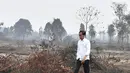 Presiden Joko Widodo atau Jokowi memeriksa kerusakan akibat kebakaran hutan dan lahan (karhutla) di Pekanbaru, Riau, Selasa (17/9/2019). Tanpa mengenakan masker, Jokowi turun langsung ke lahan gambut yang sudah habis terbakar. (Handout/Indonesian Presidential Palace/AFP)