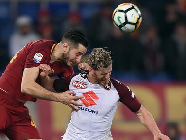 Pemain AS Roma, Kostas Manolas (kiri) berusaha menyundul bola dari pemain Torino, Cristian Ansaldi pada laga Serie A di Olympic Stadium, Roma, (9/3/2018). Roma menang 3-0. (AFP/Filippo Monteforte)