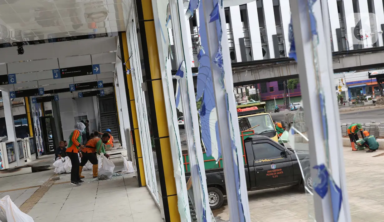 Petugas PPSU membersihkan sisa pecahan kaca di halte transjakarta Senen, Jakarta, Jumat (9/10/2020). Unjuk rasa menentang disahkannya Omnibus Law UU Cipta Kerja berujung aksi anarkis merusak berbagai fasilitas umum pada Kamis malam (8/10). (Liputan6.com/Helmi Fithriansyah)