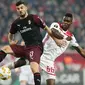 Pemain AC Milan Patrick Cutrone dan pemain Olympiakos Piraeus, Pape Abou Cisse berebut bola dalam laga keenam Grup F Liga Europa di Stadion Georgios Karaiskakis, Kamis (13/12). Milan tersingkir dari Liga Europa setelah kalah 1-3. (AP/Petros Giannakouris)