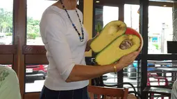 Seorang wanita Hawaii, Pamela Wang berpose dengan buah alpukat super jumbo di Kealakekua, 28 November 2017. Pamela Wang tak sengaja menemukan buah alpukat ini di pinggir jalan saat ia ingin mengambil koran miliknya. (facebook.com/pamela.b.wang)