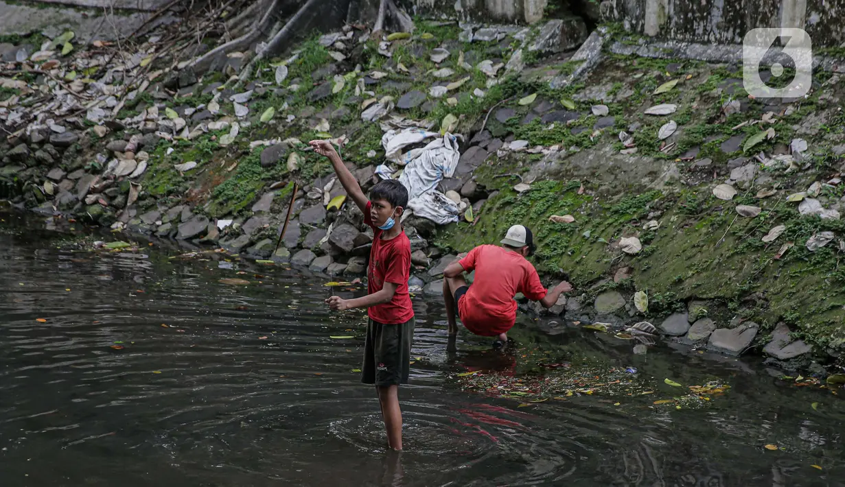Seorang anak menunjukkan belut yang didapatnya di anak kali menteng, Jakarta, Selasa (8/6/2021). Ruang bermain anak-anak di Jakarta kian terbatas. Terbatas lahan bermain membuat anak-anak Jakarta bermain ditempat yang tak semestinya demi mencari kesenangan. (Liputan6.com/Faizal Fanani)