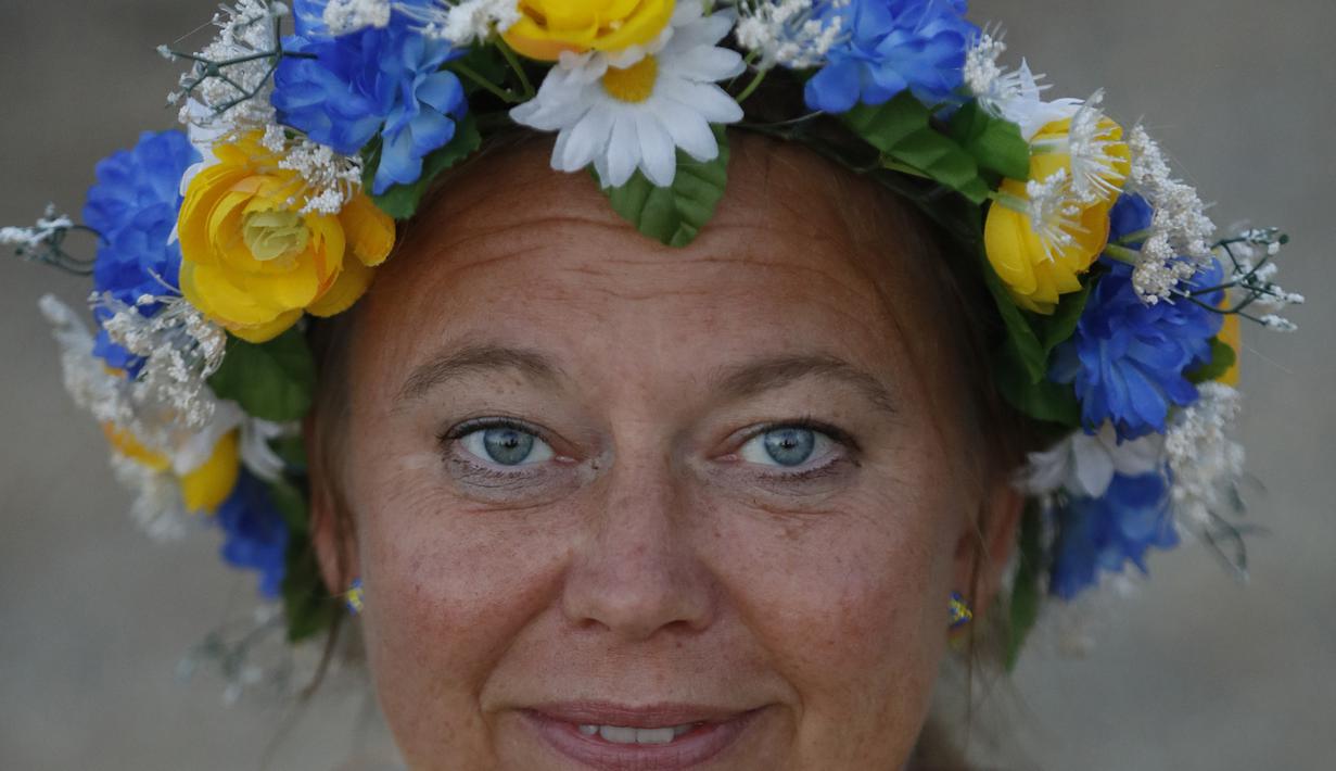 Seorang suporter Swedia bergaya dengan hiasan kepala di sekitar Pantai Sochi, Jumat (22/6/2018). Para suporter bersiap untuk menyaksikan laga Piala Dunia 2018 antara Swedia melawan Jerman. (AP/Rebecca Blackwell)