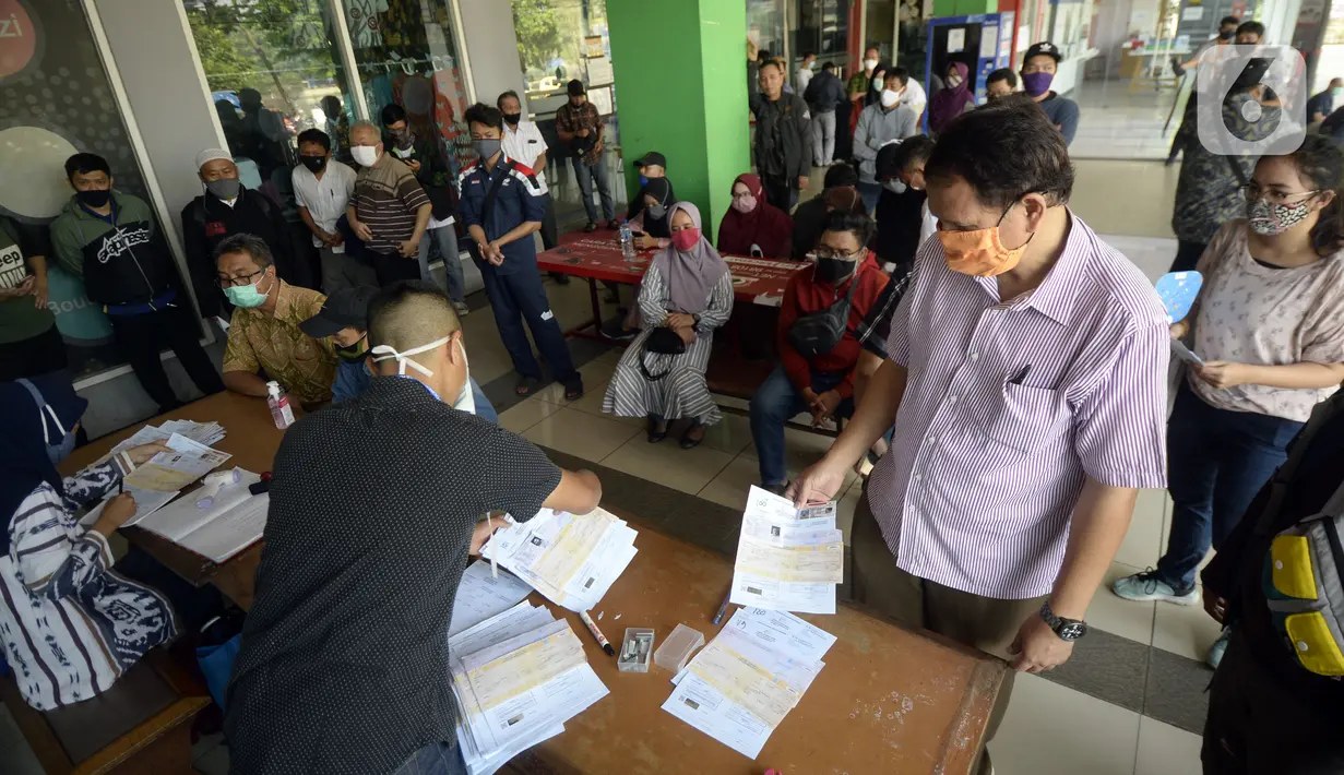 Warga antre saat mengurus SIM di Pelayanan SIM Keliling, Tangerang Selatan, Banten, Jumat (7/8/2020). Ditlantas Polda Metro Jaya memberi dispensasi bagi pemilik SIM yang masa berlakunya habis di masa pandemi COVID-19 bisa memperpanjang sampai akhir Agustus 2020. (merdeka.com/Dwi Narwoko)