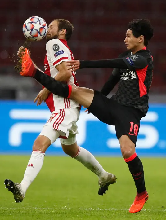 Gelandang Ajax Amsterdam, Jurgen Ekkelenkamp berebut bola dengan gelandang Liverpool, Curtis Jones pada pertandingan pertama Grup D Liga Champions 2020 di Johan Cruijff Arena, Kamis (22/10/2020) dini hari WIB. Liverpool susah payah menang tipis 1-0 di kandang Ajax. (AP Photo/Peter Dejong)