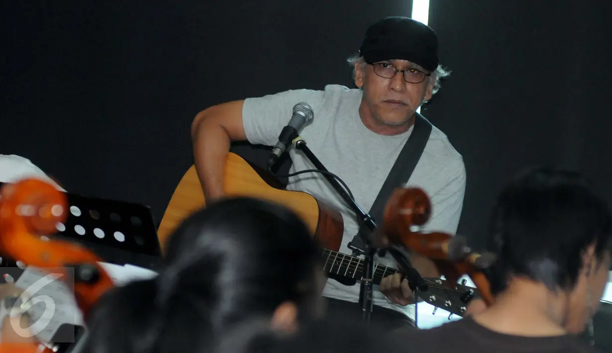 Musisi legendaris, Iwan Fals menjalani sesi latihan bersama Erwin Gutawa Orchestra, Jakarta, Minggu (21/8). Iwan Fals menuturkan akan menampilkan sajian yang spektakuler di HUT SCTV ke-26 dengan iringan musik orkestra. (Liputan6.com/Helmi Afandi)