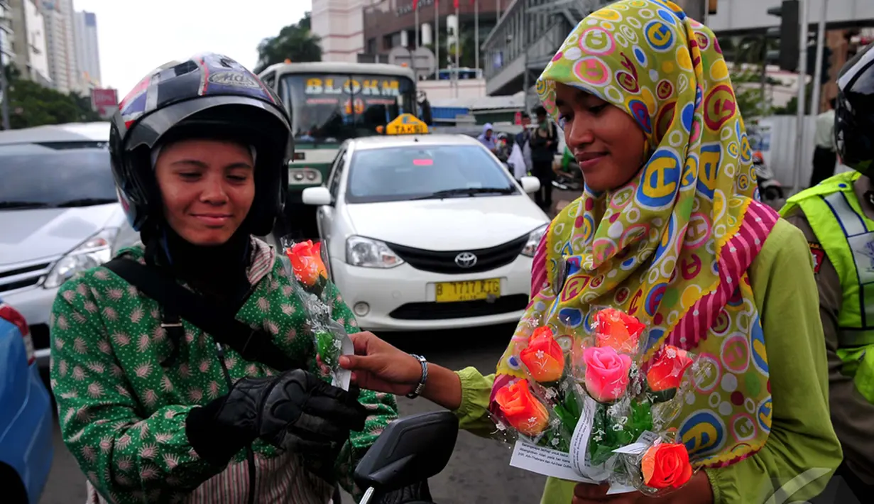 Pengendara sepeda motor saat mendapatkan bunga dari seorang mahasiswi dalam memperingati Hari Ibu,  Jakarta,Minggu (22/12/2014) (Liputan6.com/Johan Tallo)