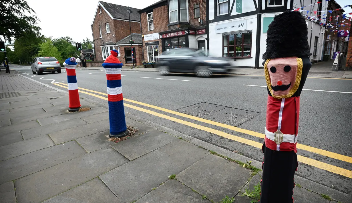 <p>Boneka rajutan berbentuk penjaga Inggris dipajang di sebuah tiang di jalan-jalan Holmes Chapel, barat laut Inggris, pada 30 Mei 2022. Sebuah kelompok masyarakat lokal, The Holmes Chapel Community Yarn Bombers telah memenuhi desa dengan barang-barang rajutan patriotik untuk merayakan Platinum Jubilee Ratu. (Paulus ELLIS / AFP)</p>