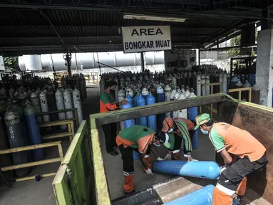 Petugas DLH memindahkan tabung saat pengisian ulang oksigen di depot PT Tirtobumi Aneka Industri, Pulogadung, Jakarta, Minggu (11/7/2021). Pemprov DKI mengerahkan petugas PJLP untuk pengisian sekaligus pendistribusian tabung oksigen ke rumah sakit rujukan Covid-19. (merdeka.com/Iqbal S. Nugroho)