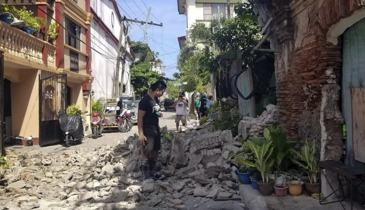 Seorang pria berdiri di samping sebuah rumah yang rusak setelah gempa kuat melanda Vigan, Provinsi Ilocos Sur, Filipina, 27 Juli 2022. Gempa bermagnitudo 7 yang mengguncang Filipina dilaporkan berpusat di daerah pegunungan di Provinsi Abra. (Bureau of Fire Protection via AP)