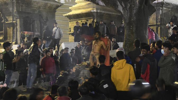 Seorang Sadhu (orang suci Hindu) berdiri di tangga ketika umat mengunjungi Kuil Pashupatinath pada malam festival Hindu Maha Shivaratri di Kathmandu (20/2/2020). Maha Shivaratri, sebuah festival Hindu yang dirayakan sebelum kedatangan musim semi. (AP/Niranjan Shrestha)