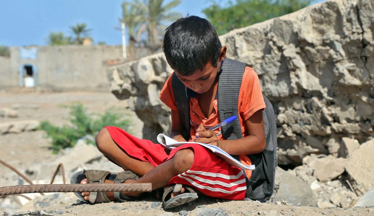Anak-anak Yaman menghadiri kelas di luar ruangan sebuah sekolah yang rusak parah pada hari pertama tahun ajaran baru di provinsi barat Yaman yang dilanda perang Hodeida, Senin (17/10/2022). UNICEF memperkirakan bahwa lebih dari dua juta anak telah putus sekolah di Yaman, peningkatan hampir setengah juta sejak perang pecah pada 2015. (Foto oleh Khaled ZIAD / AFP).