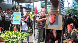 Sejumlah aktivis dari Koalisi Masyarakat Sapu Koruptor mengenakan topeng berwajah Taufiequrachman Ruki dan Presiden Jokowi saat menggelar aksi damai dan teatrikal di depan Gedung KPK, Jakarta, Rabu (4/3/2015). (Liputan6.com/Yoppy Renato)