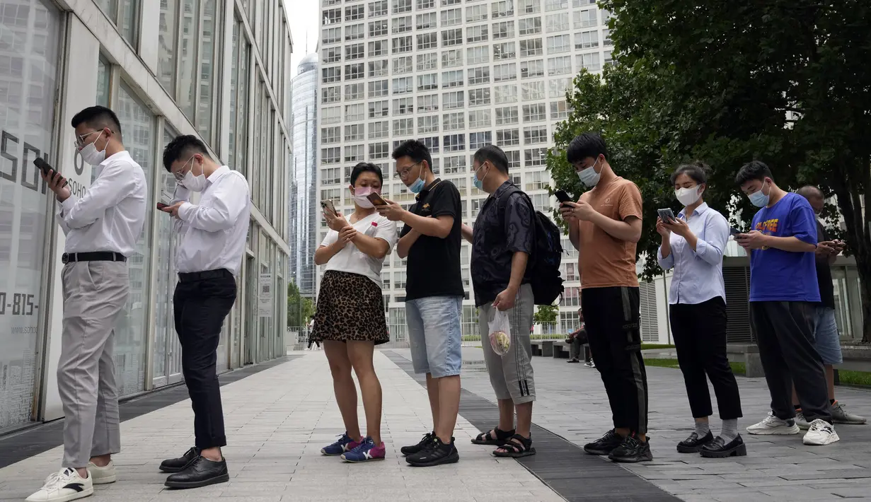 Warga yang mengenakan masker berbaris untuk tes COVID-19 di Beijing, China, 12 Juli 2022. Beijing telah membatalkan rencana untuk mengizinkan hanya orang yang divaksinasi yang memasuki ruang publik. (AP Photo/Ng Han Guan)