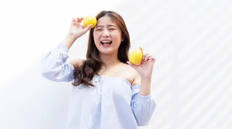 perempuan tersenyum membawa jeruk
