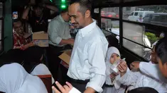 Ketua KPK Abraham Samad membagikan takjil di dalam bus Kopaja, Kamis (24/07/14). (Liputan6.com/Faisal R Syam)