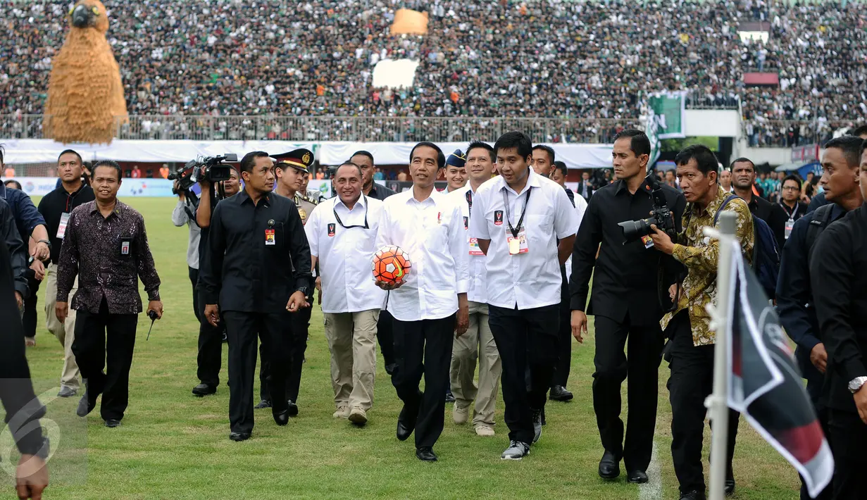 Presiden Joko Widodo (tengah) bersiap melempar bola saat pembukaan turnamen Piala Presiden 2017 di Stadion Maguwoharjo, Sleman, Sabtu (4/2). Sekitar 31.000 penonton menyaksikan laga pembuka turnamen Piala Presiden 2017. (Liputan6.com/Helmi Fithriansyah)