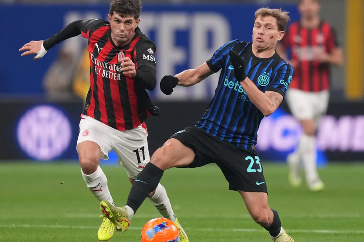 Christian Pulisic dari AC Milan (kiri) berebut bola dengan Nicolo Barella dari Inter Milan