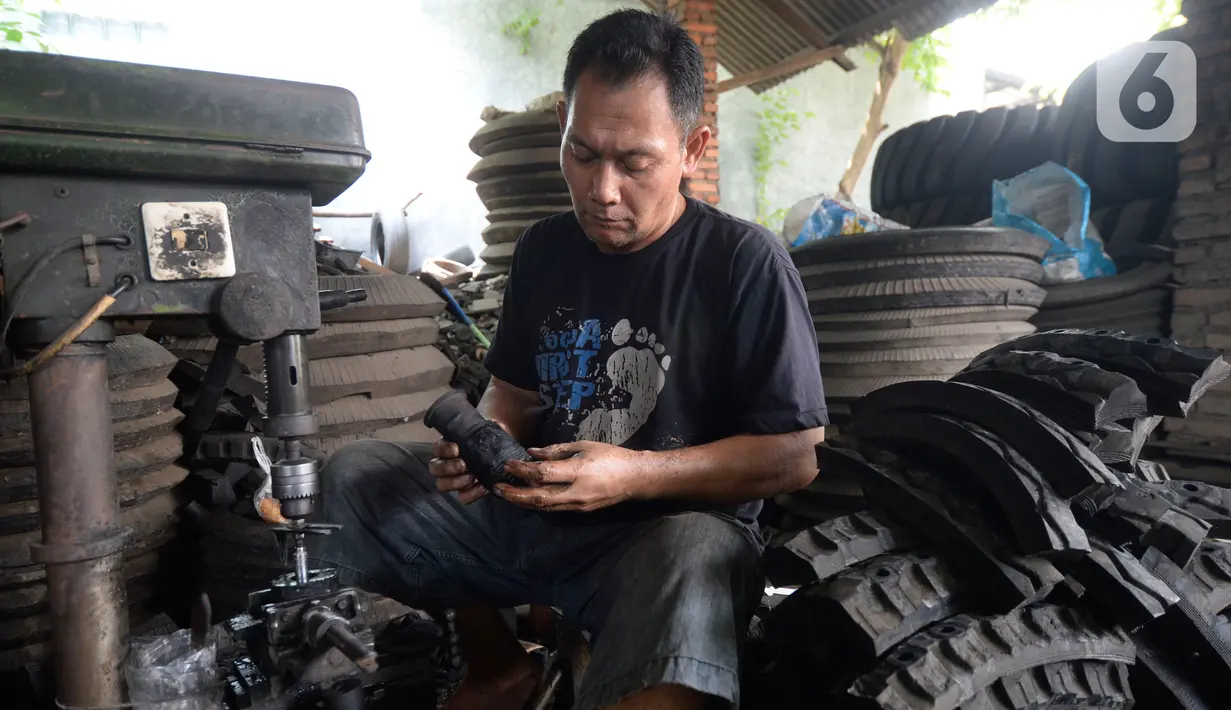 Pekerja membuat karet bushing stabilizer dan karet engine mounting khusus mobil yang terbuat dari ban bekas alat berat di Bambu Papus, Tangerang Selatan, Rabu (11/11/2020). Pada masa pendemi pemesanan karet bushing menurun hingga 50 persen kini berlahan-lahan mulai stabil. (merdeka.com/Dwi Narwoko)